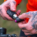 Cyclist holding Muc-Off Road CO2 Inflator Kit on ride