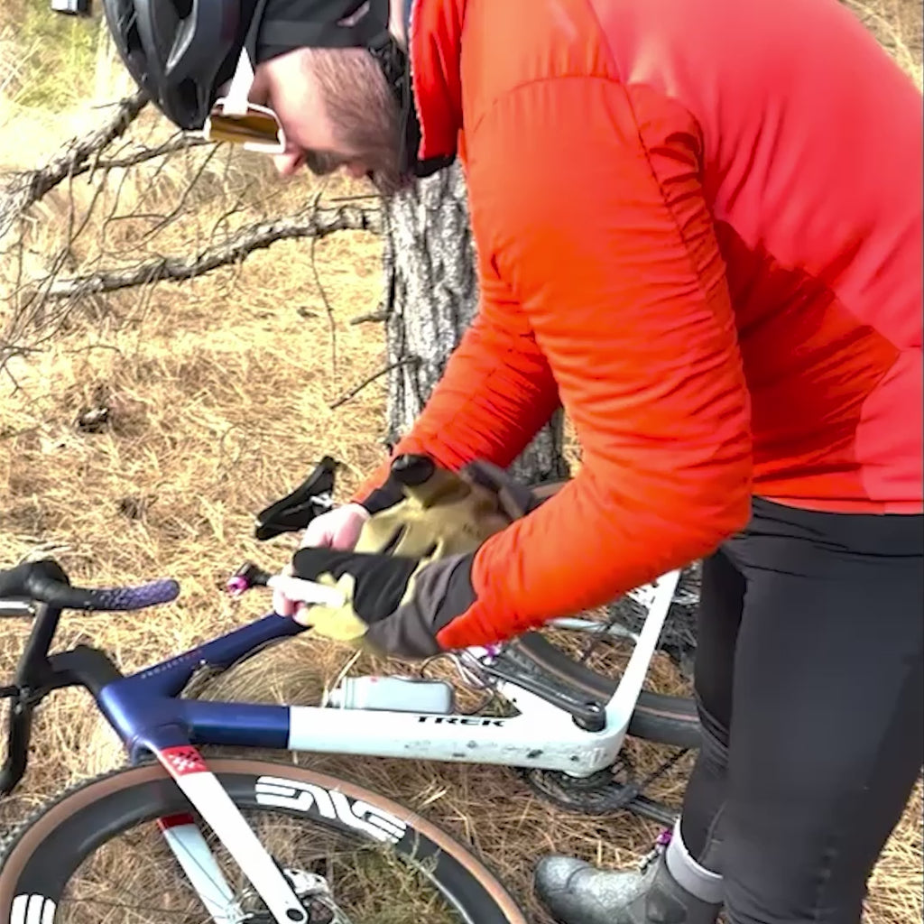 Cyclist inflating flat tire with Muc-Off CO2 Inflator Kit