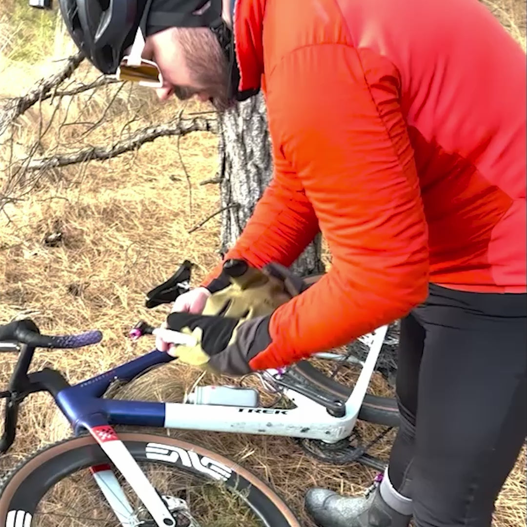 Cyclist inflating flat tire with Muc-Off CO2 Inflator Kit
